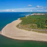 Widok z lotu ptaka na piaszczystą plażę, las i miasteczko na Helu.